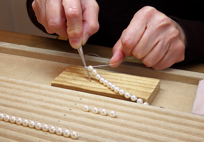 真珠のネックレスの糸替え作業中の手元